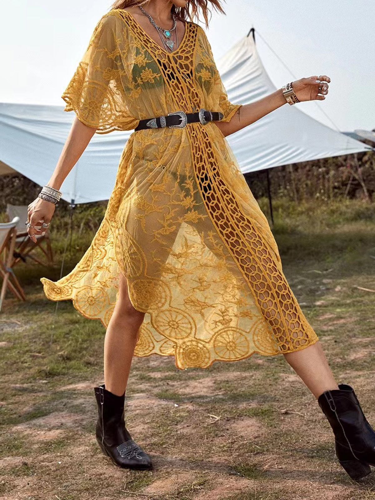woman wearing a yellow sheer lace maxi cover-up with high side slits, belted at the waist