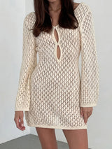 Woman wearing a cream-colored open knit mini dress with long sleeves and a keyhole neckline.