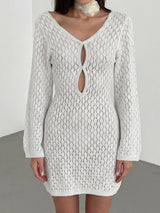 Woman wearing a white open knit mini dress with long sleeves and a keyhole neckline.