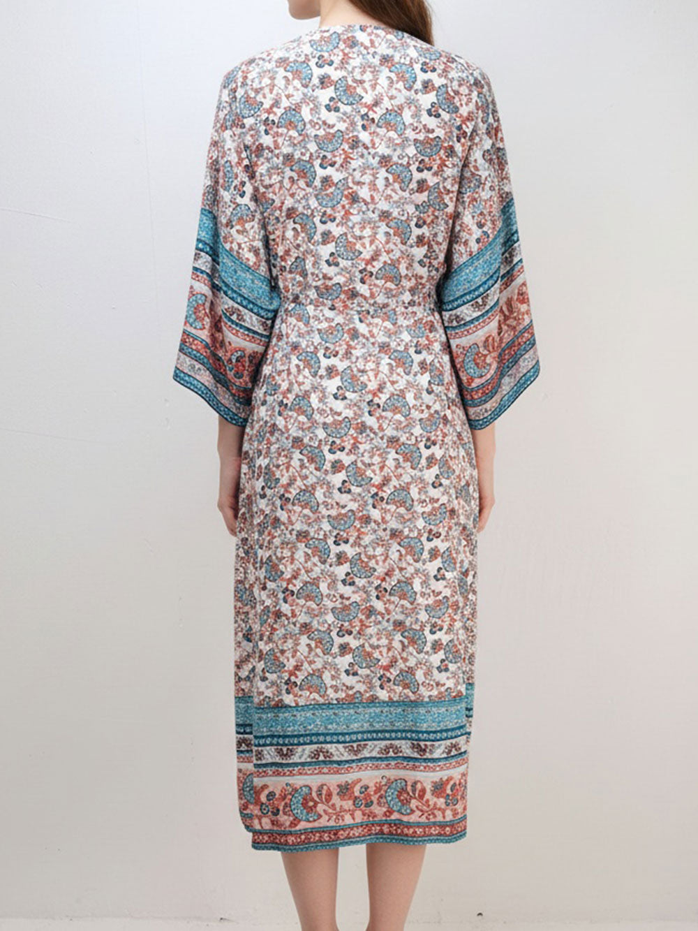 Back view of a woman wearing a long, floral print kimono dress.