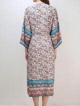 Back view of a woman wearing a long, floral print kimono dress.