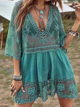 Woman wearing a teal lace cover-up dress