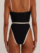 Back view of a black one-piece swimsuit with cream trim, showing a square neckline and high-cut leg design.