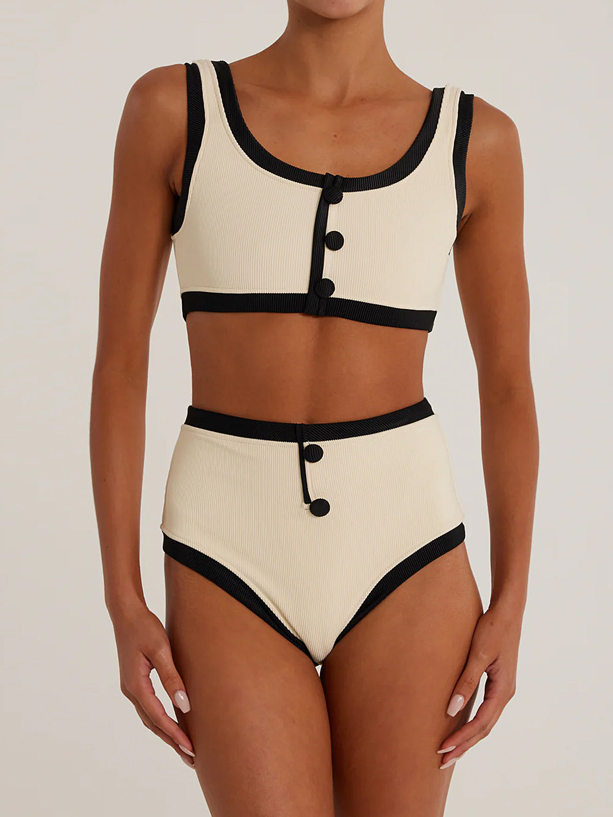 Woman wearing a cream and black ribbed bikini set, front view