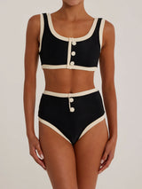 Woman wearing a black and cream ribbed bikini set, front view