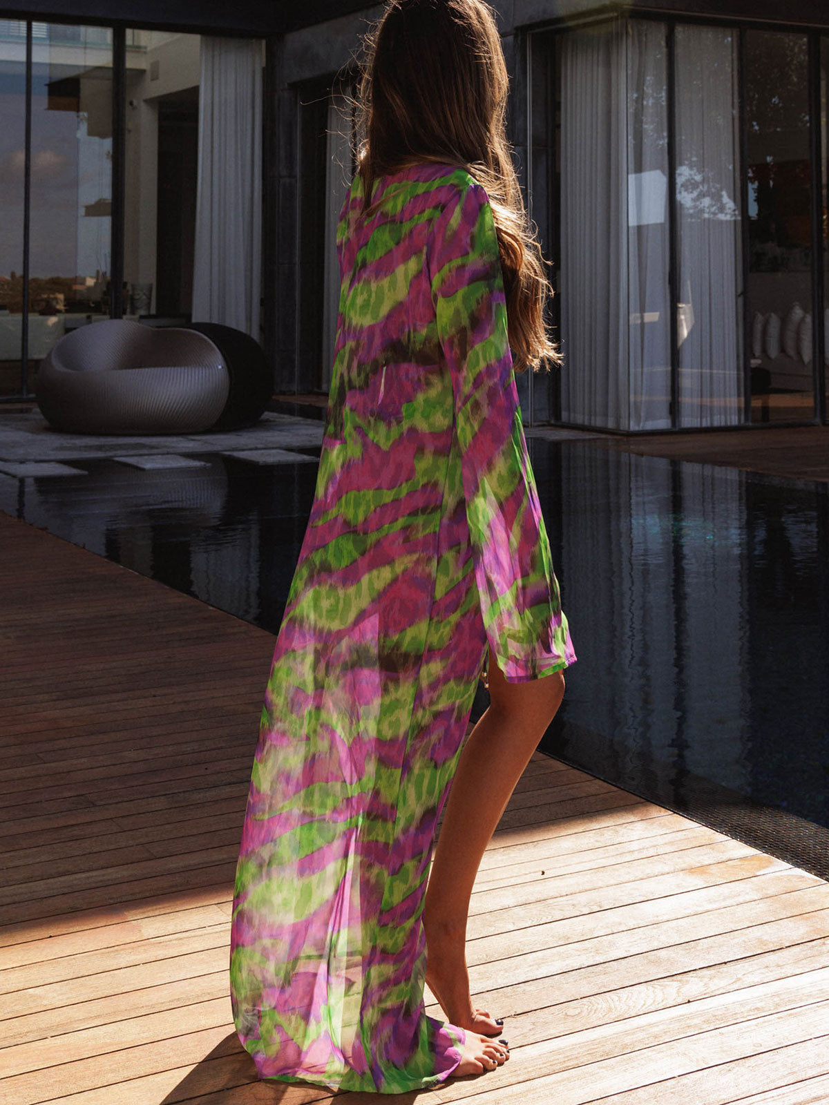 Back view of a woman wearing a long, flowing, tie-dye print kimono.