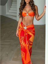 Woman in an orange floral print strapless bikini top and matching maxi sarong, front view.