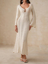 Woman wearing a cream knit maxi dress with bell sleeves and a keyhole neckline.