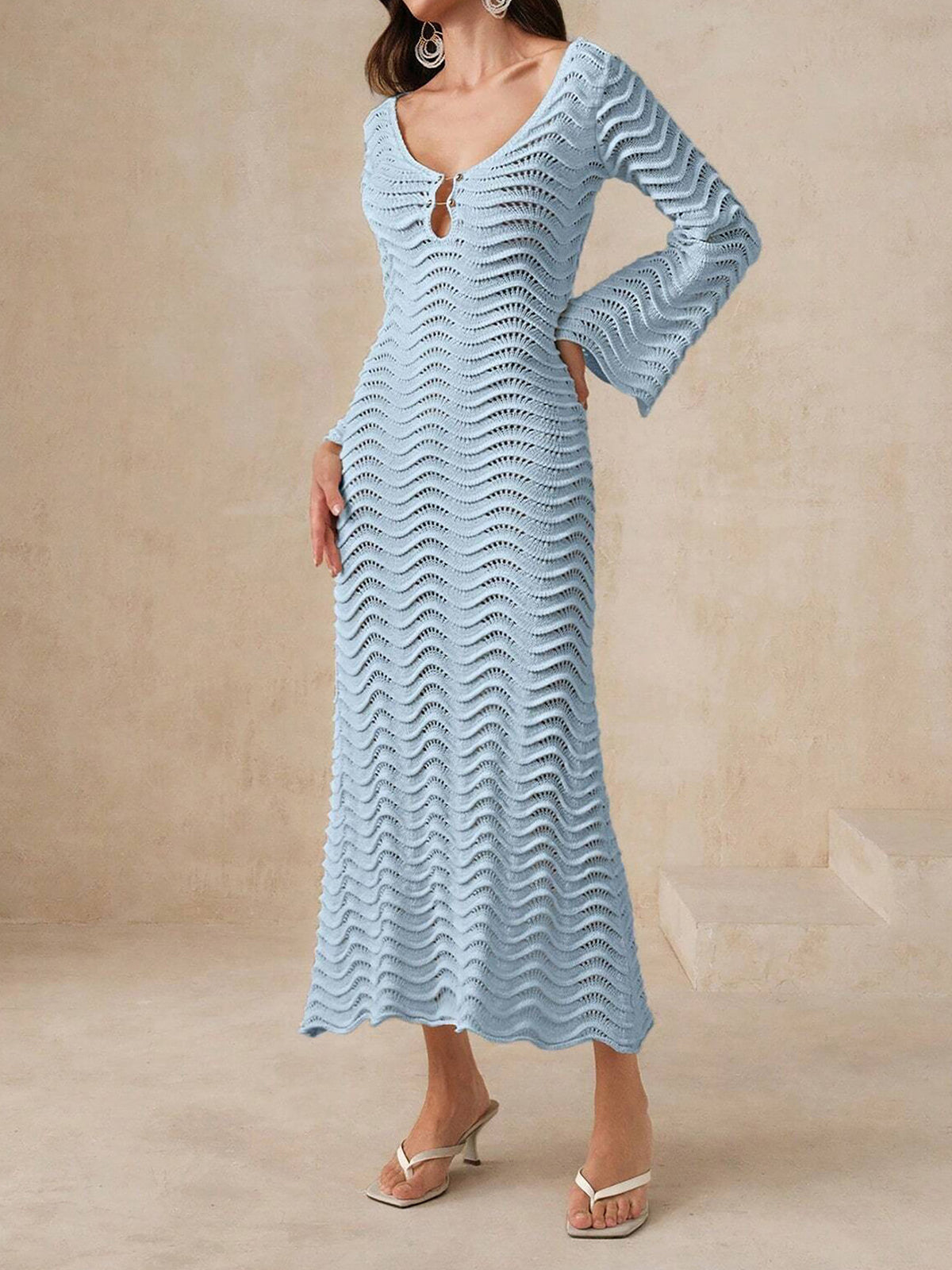 Woman wearing a cream knit maxi dress with bell sleeves and a keyhole neckline from the front.