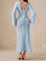 Woman wearing a light blue knit maxi dress with bell sleeves and a keyhole neckline from the front.