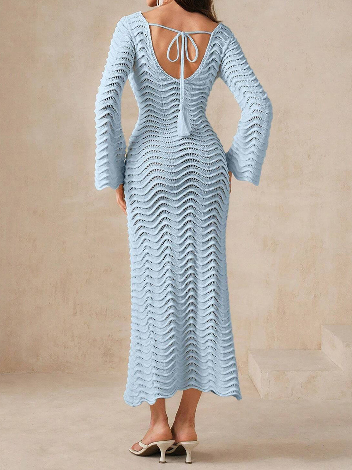 Woman wearing a light blue knit maxi dress with bell sleeves and a keyhole neckline from the front.