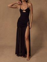 Woman wearing a black halter maxi dress with a cutout bust and a high slit