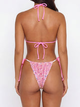Back view of a woman wearing a pink sequined bikini with pearl accents.