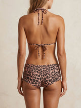 Back view of a woman wearing a leopard print bikini set with a triangle top and boy short bottoms.