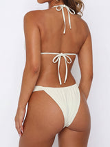 Back view of a woman wearing a light-colored bikini set