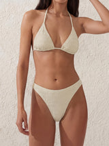 Woman wearing a textured cream bikini set.