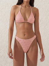 Woman wearing a textured pink bikini set.