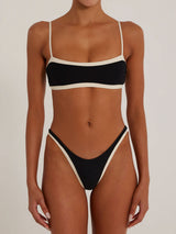 Front view of a black and cream bikini set on a model