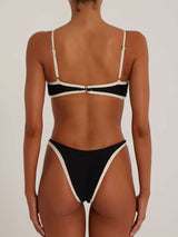 Back view of a black and cream bikini set on a model