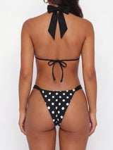 Back view of a woman in a black and white polka dot bikini with adjustable ties