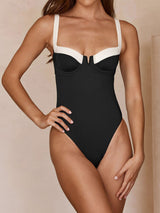Front view of a black and white one-piece swimsuit on a model