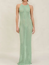 woman wearing a long, light green, chevron-patterned knit halter dress