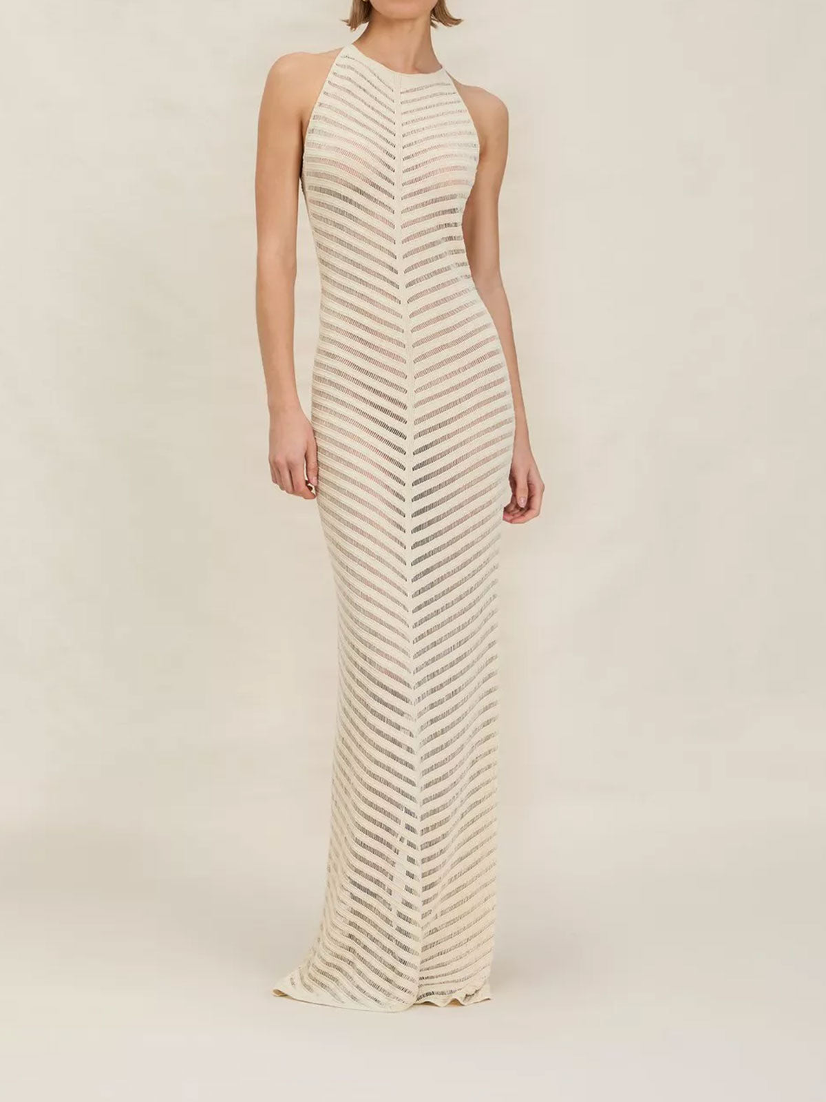 woman wearing a long, cream, chevron-patterned knit halter dress
