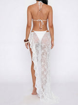 back view of a woman in a white bikini and white lace sarong