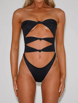 Front view of a black strapless one-piece swimsuit with cut-out details and twisted knot accents.