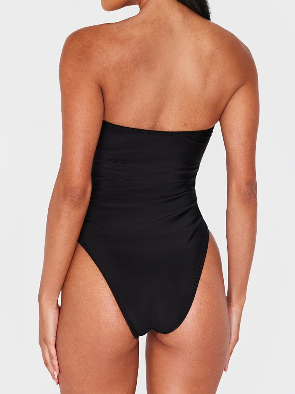 Back view of a black strapless one-piece swimsuit.