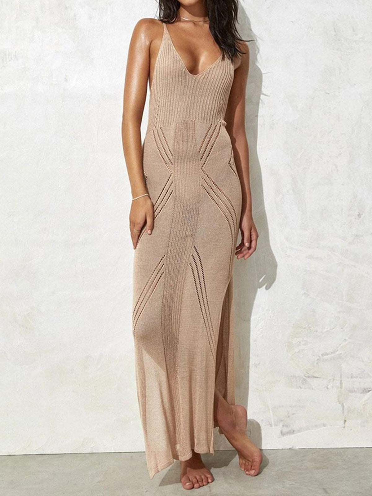 woman wearing a beige knit maxi dress with geometric cutouts and a high slit