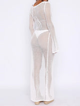Back view of a woman in a white crochet mesh maxi dress with a hood and high slit against a white background.