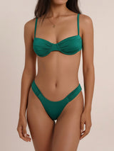 Woman wearing a deep green ruched bikini set
