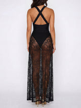 Back view of a woman in a black maxi dress with a sheer lace overlay and crisscross straps.