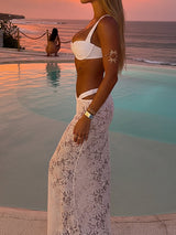 Side view of a woman in a white lace maxi skirt and bikini set