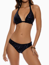 Woman wearing a black sequined halter neck bikini set