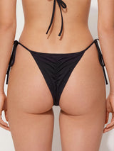 Back view of black thong bikini bottom with adjustable side ties and ruched detailing
