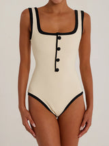 Cream one-piece swimsuit with black trim and buttons, front view